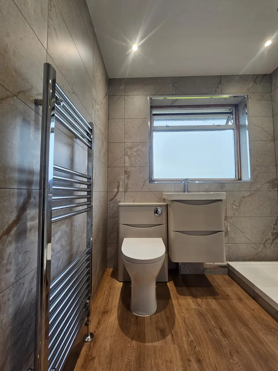 Shower room with white vanity and wood-effect flooring